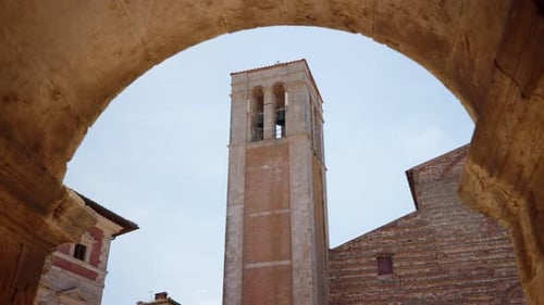 Von einem Steinbogen eingerahmter Glockenturm in Montepulciano, Toskana