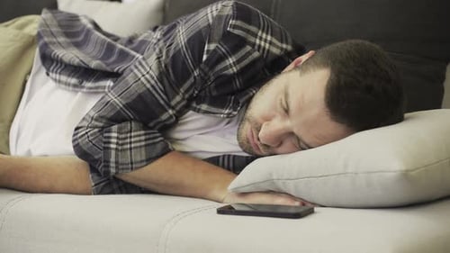 Caucasian Man Lying on Sofa Feeling Tired in Living Room at Home Slow Motion