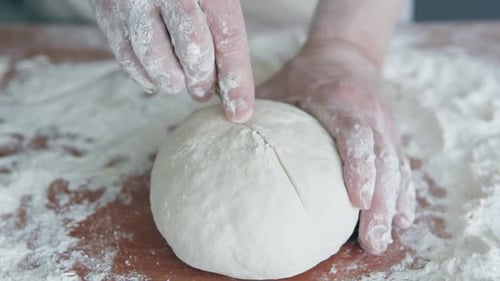Baker Kneading and Scoring Fresh Dough