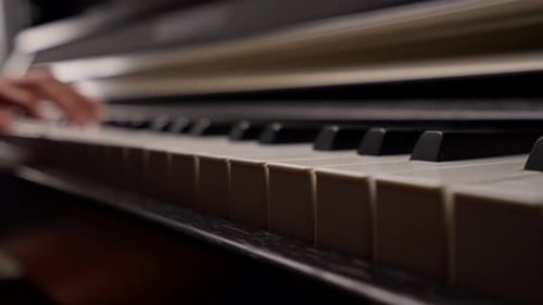 Close-up of a woman's hands in silver rings playing beautiful lyrical melody on the piano keys
