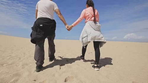 A Couple Holding Hands on a Beach