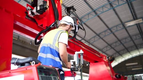 El operador de fábrica controla el brazo robótico automatizado en la línea de producción. Industria tecnológica.