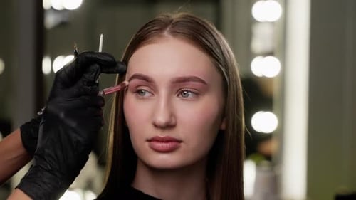 Woman Getting Eyebrows Done in Makeup Studio