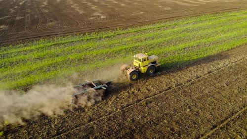 Aerial View of Vintage Powerful Yellow Tractor Ploughs Field with Plow Discs on Large Scale Farm