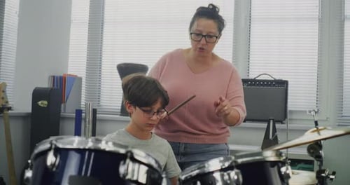 Primary School Boy Practicing Sense of Rhythm Playing Drums in Music Class