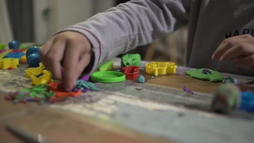 Child Plays with Plasticine and Colorful Molds