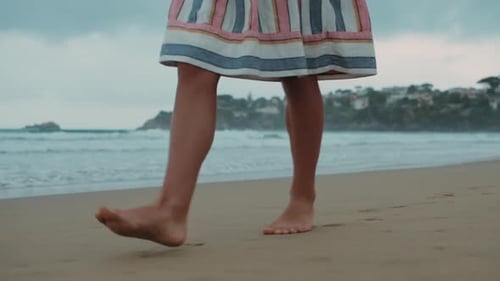 Barefoot legs walking on sandy ocean beach