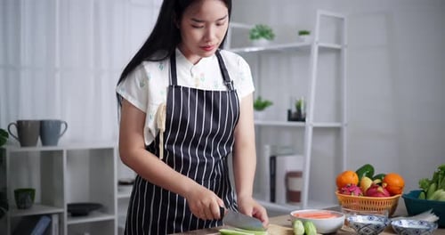 Woman Chopping Cucumber in Kitchen for Healthy Eating