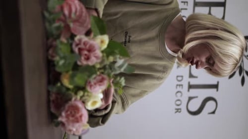Florist makes bouquet in flower shop Vertical Elya