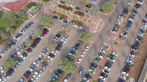 Vista aérea de los automóviles que entran, salen y buscan espacio de estacionamiento disponible