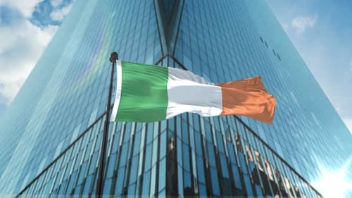 Irish Flag Waving in Front of Modern Corporate Building