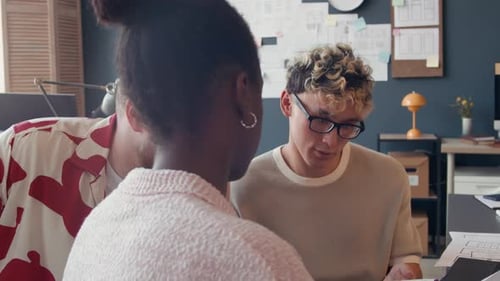 Black Female UI Designer Discussing Sketch with Male Colleagues at Office