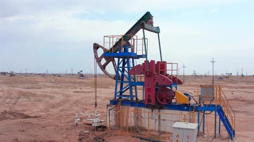 Colorful Oil Pumpjack in Desert Landscape Filmed By Drone