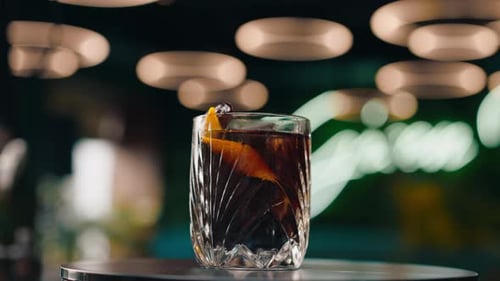 freshly prepared black alcoholic cocktail rotates on the bar counter in the bar-club