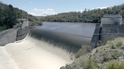 Pan shot of water flowing on the dam. view of the river channel.