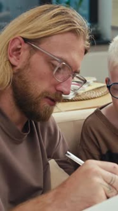 Man and Child Drawing Together at Home