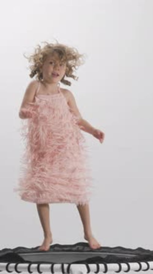 Happy Child Jumps on Trampoline in Studio