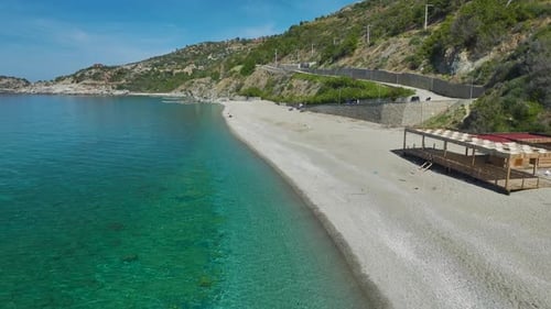 Aerial Shot of Sandy Beach and Winding Coastal Road