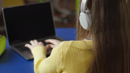 Child Learning on Laptop with Headphones Indoors