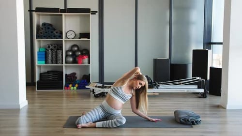 Prenatal Fitness Coach Guides Through Safe Back Stretching Pose