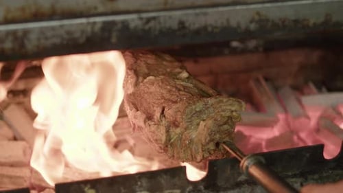 Cook roasts juicy brazilian barbecue kebab on the grill slowmotion