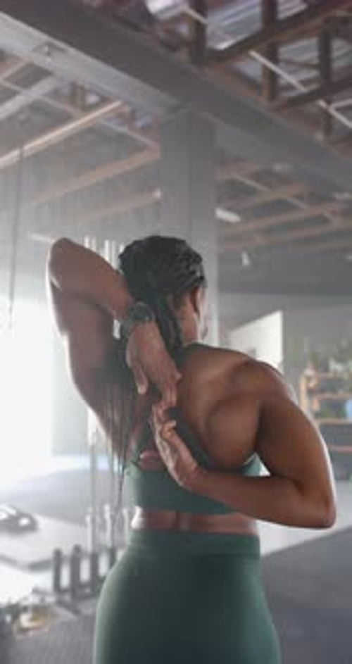 Vertical video: Stretching in gym, woman in sportswear preparing for workout session