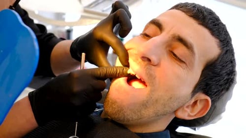 Man Receiving Dental Treatment in Clinic, Bright Light