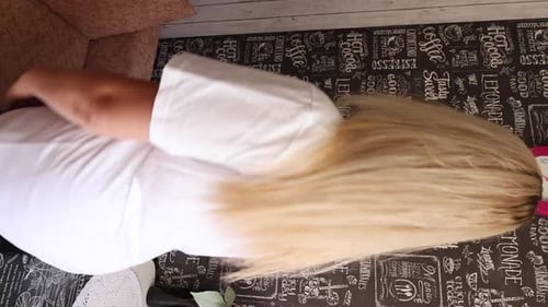 La mujer se pone una camiseta y demuestra la compra. Vídeo vertical.