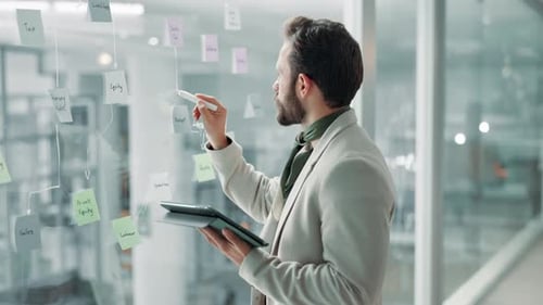 Bearded Man Strategizing in Modern Office With Tablet