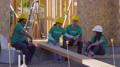 Construction volunteers take a break and drink water