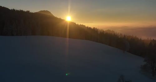 A Beautiful and Peaceful Winter Sunset Casting Warm Colors Over a Snowy Landscape