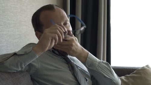 Tired man yawning on the couch indoors