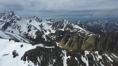 Rotating cinematic breathtaking drone shot of the snow covered Georgian Dolomites in the Caucasus mo