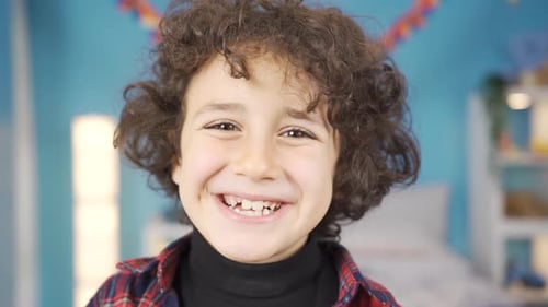 Close-up of boy smiling at camera. Happiness.