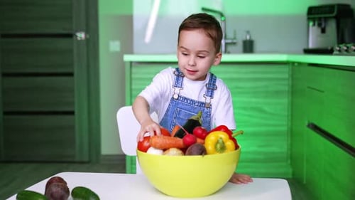 Boy with Bowl of Fresh Vegetables in Kitchen