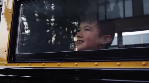 crianças no ônibus escolar - Criança de aparência otimista na janela do ônibus escolar