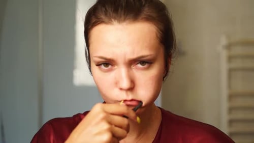 Young Woman Brushing Her Teeth Looking in the Mirror in Bathroom Pretty Female Doing a Morning