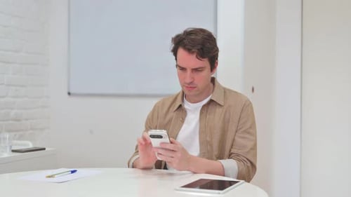 Young Man Typing Message on Phone