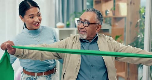 Senior Man Doing Resistance Exercise at Home with Assistant