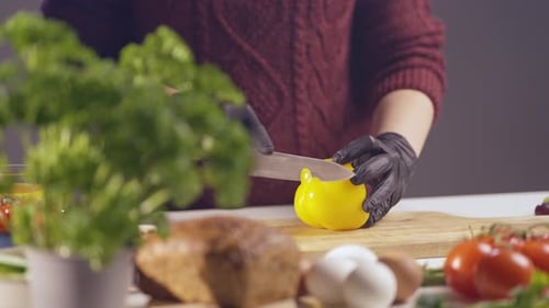 Person Slices Bell Pepper in the Kitchen