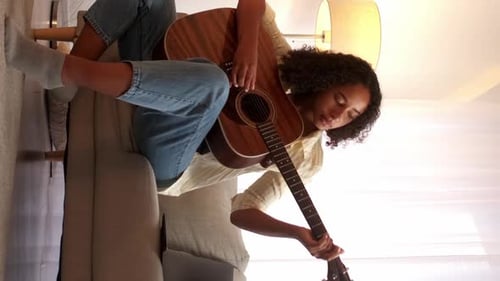 Woman Plays Acoustic Guitar on Couch