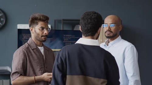 Indische männliche Programmierer diskutieren im Tech Office über ein Codierungsprojekt