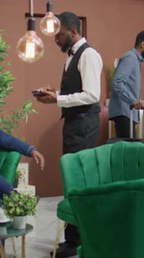 Waiter Takes Mobile Payment in Modern Waiting Area