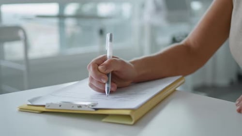 Elegante Geschäftsfrau, die in Innenräumen Notizen von Hand auf Papier schreibt, Nahaufnahme, Zeitlupe