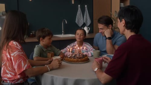 Family Celebrates Birthday with Cake in Kitchen