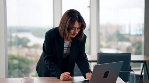 Young Woman Works on Laptop in Bright Office