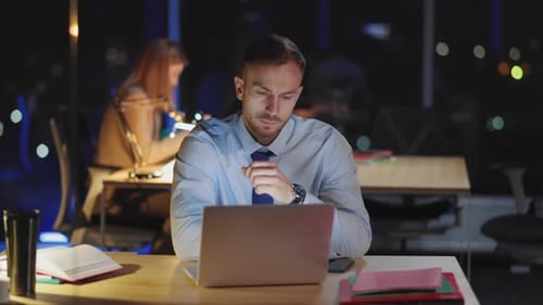 Exhausted Young Businessman Working in Coworking Space Trying to Finish Computer Project Using
