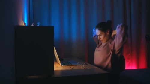 Woman Working at Laptop Computer at Night