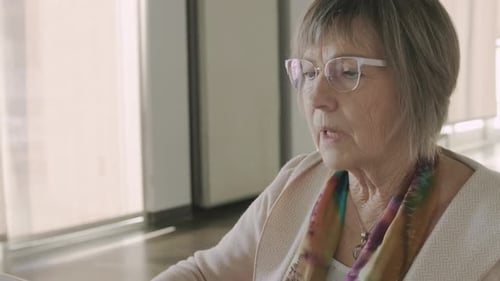 Senior Female Volunteer Using Laptop in Community Center Active
