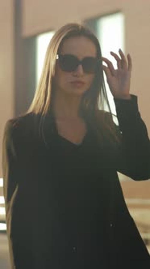 Confident Woman Shades Pose Chic Lady Adjusting Sunglasses Showcases Refined Street Style Amid City